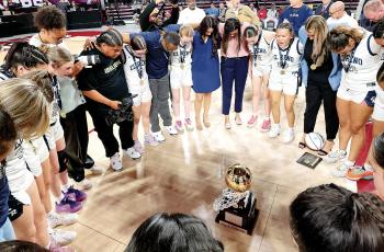 Nazhoni Sleeper leads the girls basketball team in prayer