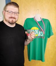 Rev. Dylan Ward shows off the official Bun Run mug and T-shirt