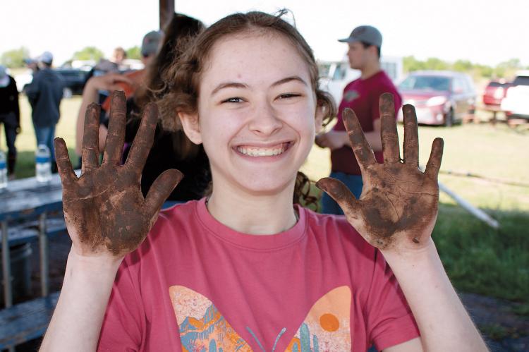Emma Selensky shows her hands after testing soil during last year’s event