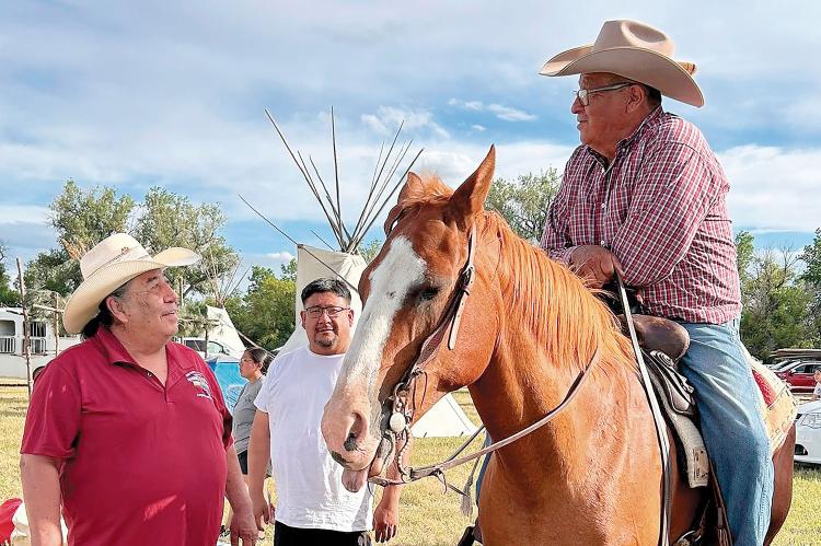 Chester Whiteman (left) visits with members of the Northern tribes