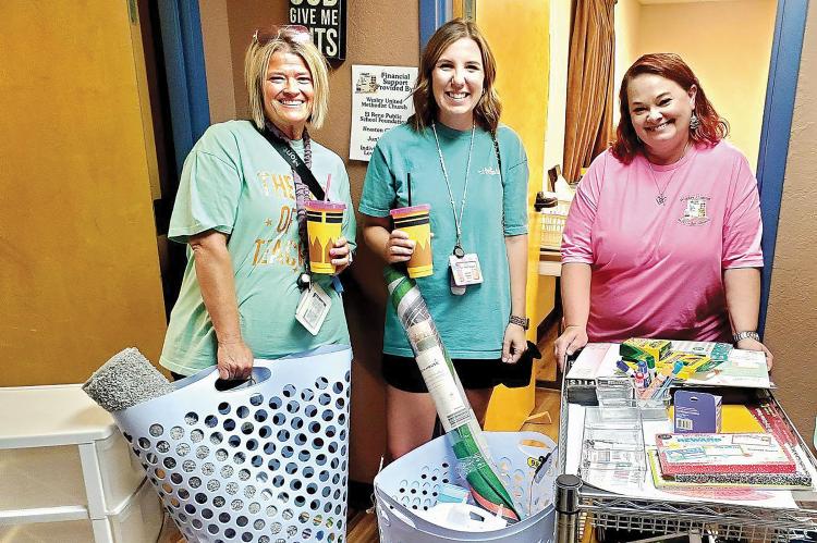 Trisha Murray (left) and Brooke Ferguson show off their new supplies with Amy Neathery (right)