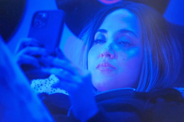 Powell is shown using a telephone to have a conversation with a suspected online predator