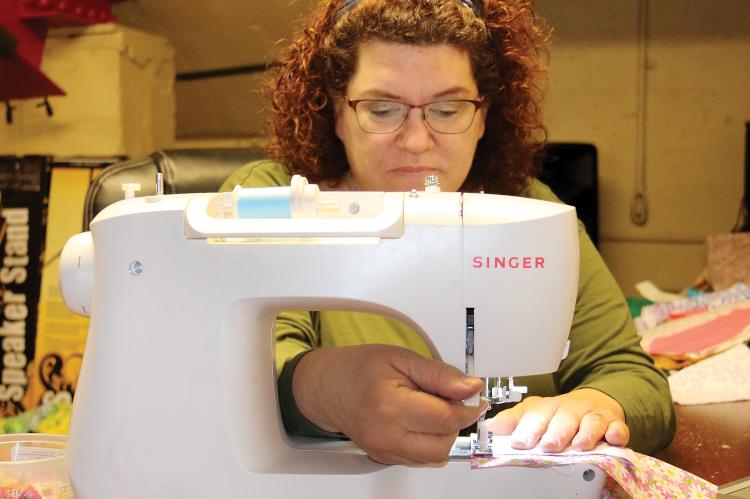 Richardson slips a lever on her sewing machine
