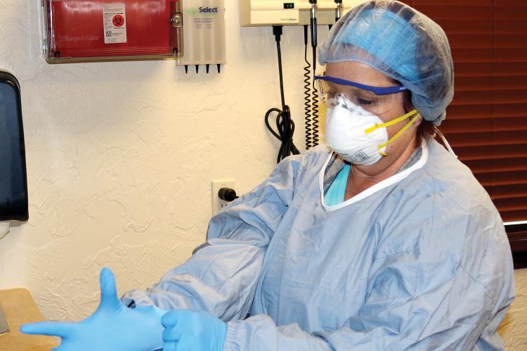 Myers puts on a full set of personal protection equipment (PPE)