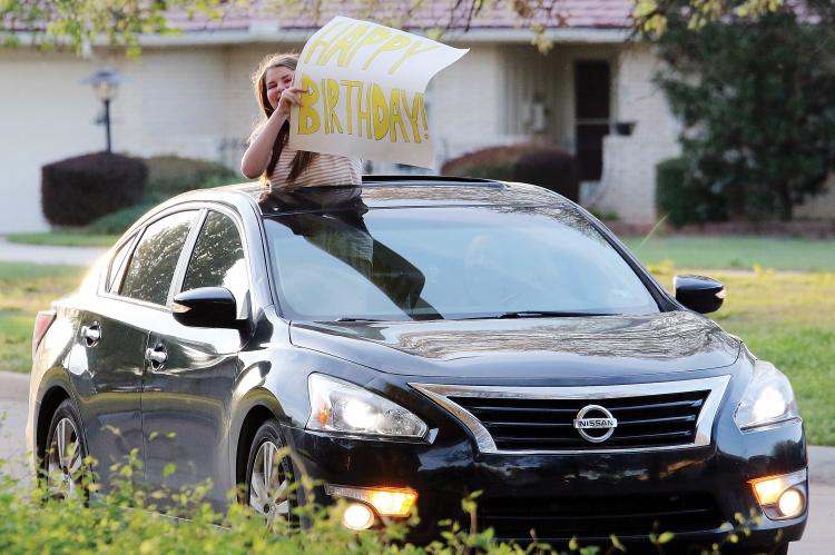 Hailey McBroom holds up a sign for best friend Caroline Huber