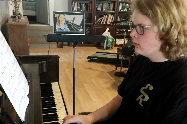 Caden Bayne practices on piano