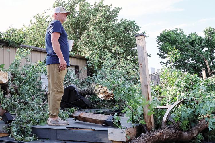 Darren Koehn stands on top of his pool deck looking over the damage to his property