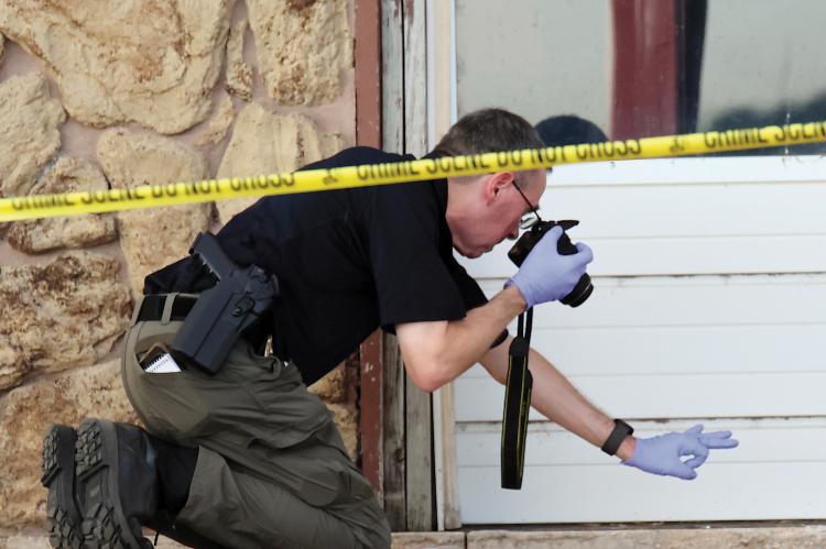 David Beaty takes a photo at a scene near where a deceased person was found Thursday morning
