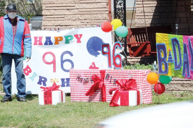 Eichholz waves at passing cars honking at the birthday signs