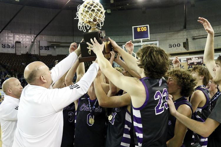 Okarche team members celebrate by holding up the Class A state title trophy