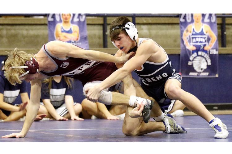 El Reno High School 132-pounder Hudson Brooks, right, grabs the knee and ankle of a Perry wrestler as he attempts a takedown in a key lower-weight match. 