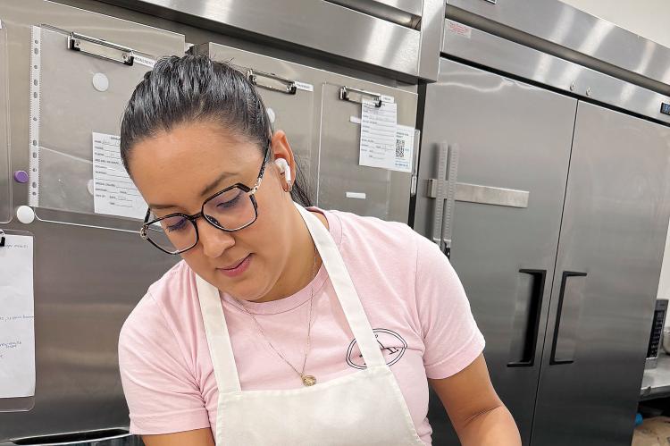 Allie Diaz putting icing on a custom cake order