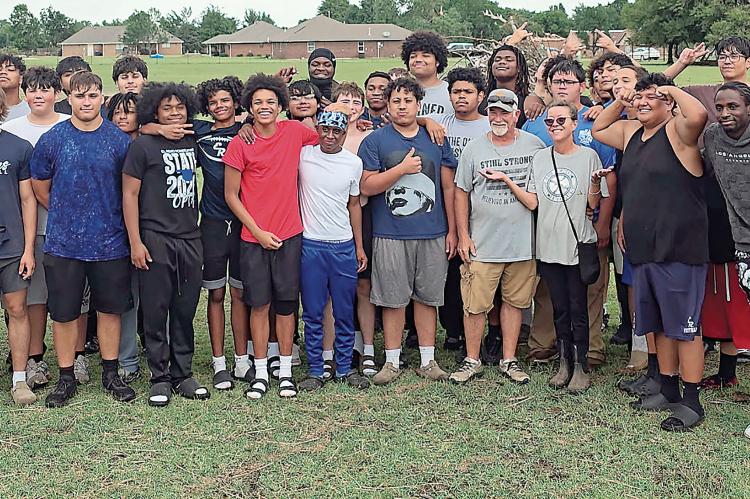 Connie Holt and husband, Bob Ballhorn (front row gray shirts) got help from the EHS football team