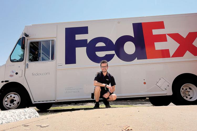 Matthew Snyder posing with his Federal Express truck