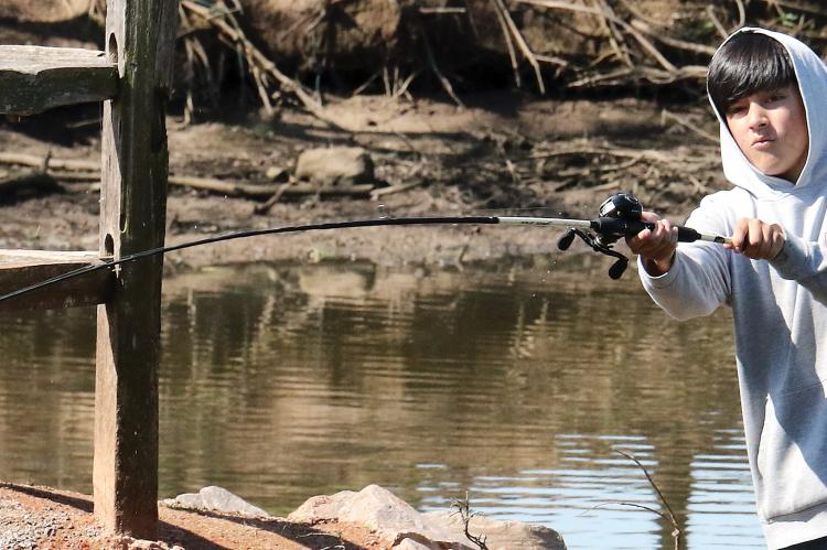Water flings off the end of the lure on Isiah Deleon's fishing pole