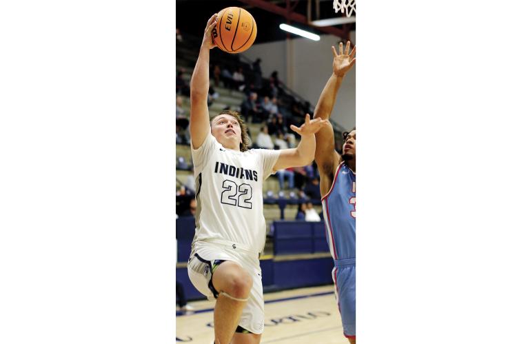 Jacob Robertson uses his arm to screen off an Eagles defender while shooting a layup. 