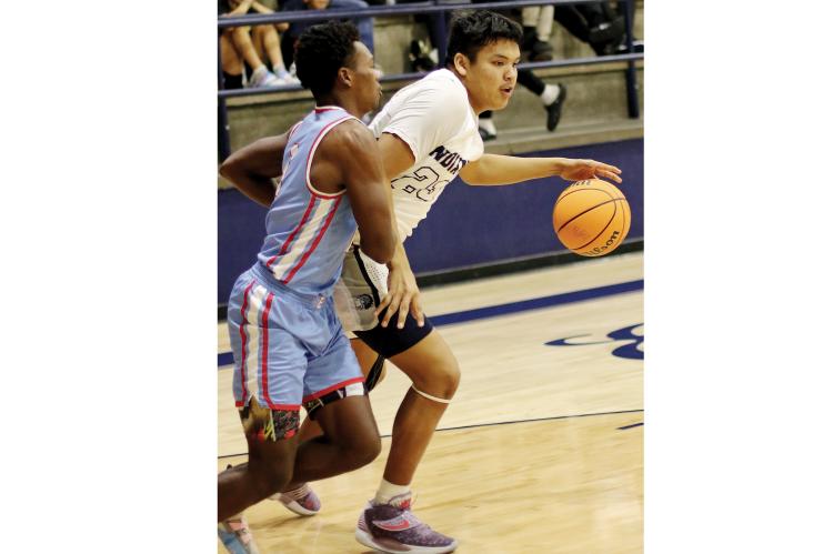 El Reno  post player James Reveles backs down a defender with his dribble before shooting.