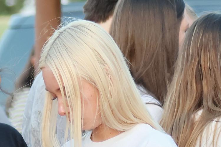 Lily Hayes bows her head during the vigil