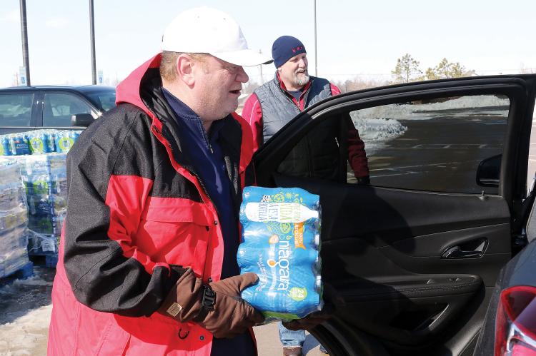 Matt White handing out cases of water during the water outage