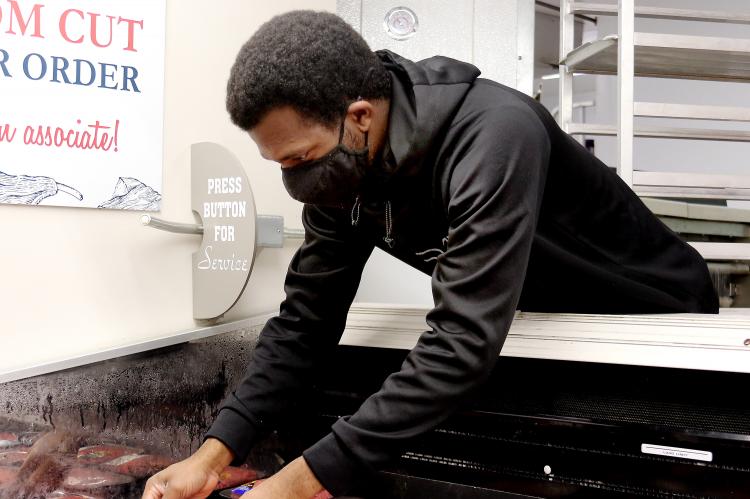 Christian Lawrence sorts packages of processed meat
