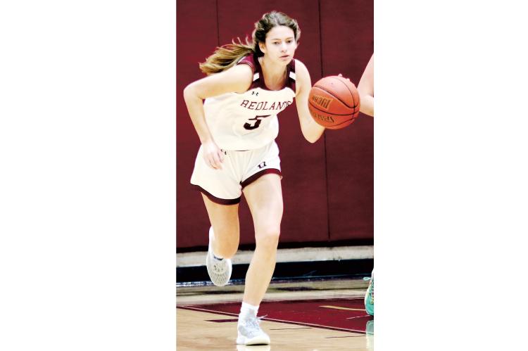 Redlands guard Macy Moore dribbes up the court. 