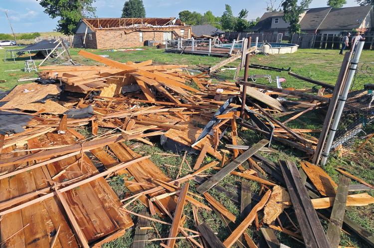 Mike Murray (back right) talks with Bobby Don Stevenson, who had stopped by to check the damage to Murray’s home