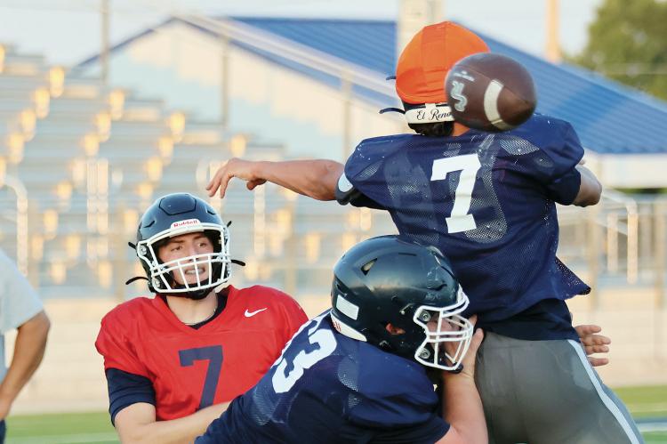 Nathan Ashmore (7) throws a pass around a defender getting blocked along the line of scrimmage