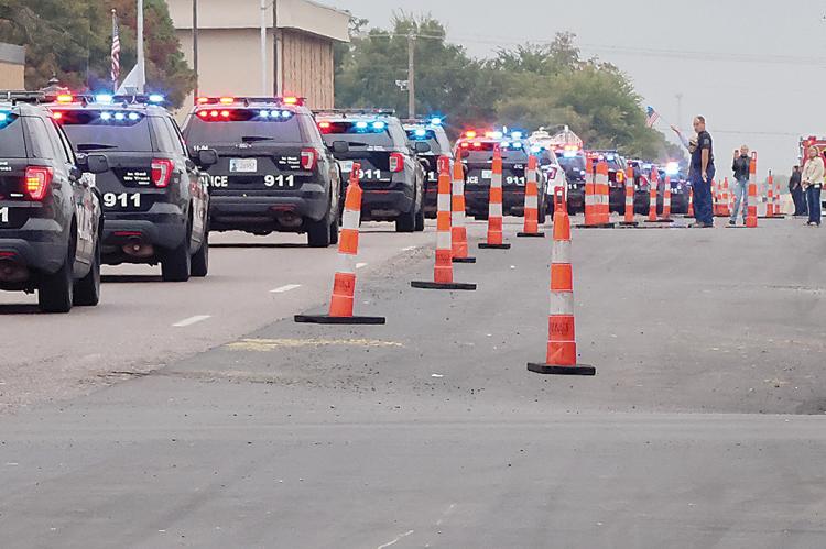 Residents, city workers and staff lined the street during the mile-long procession