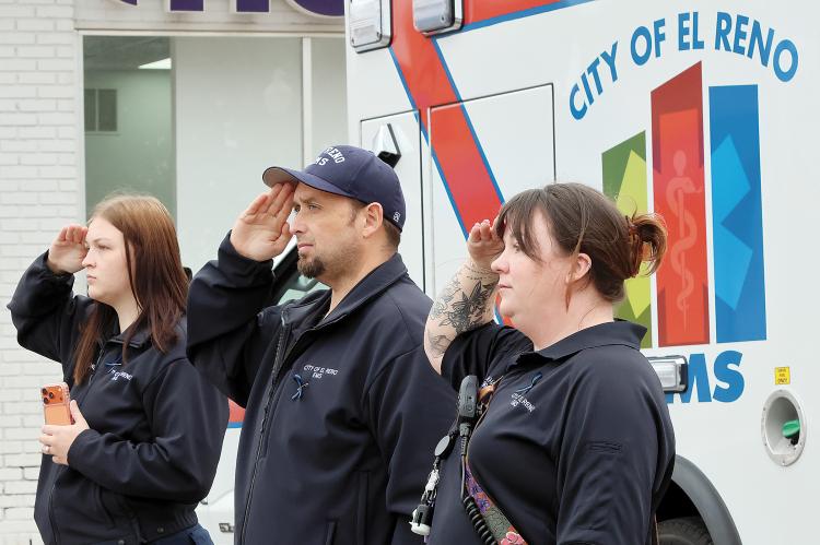 El Reno EMS workers salute as the procession passes