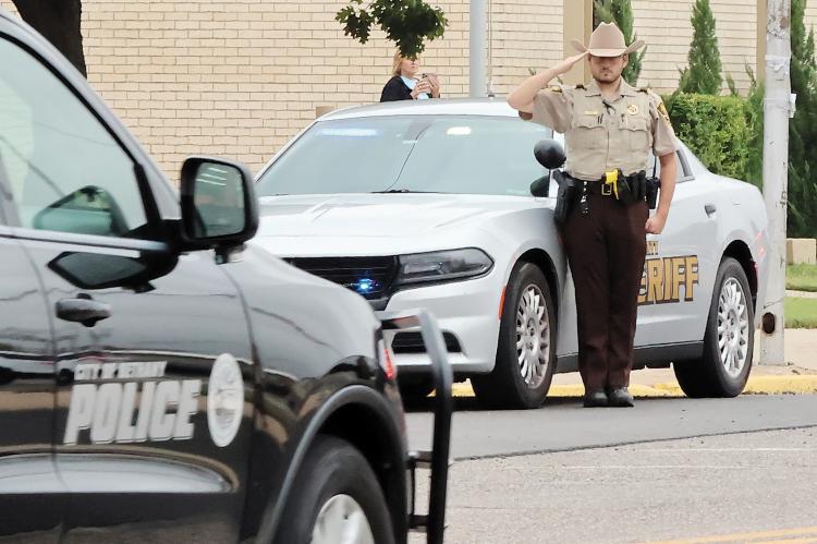 Aaron Conley salutes as the procession passes