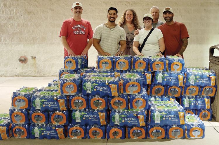 Members of Discovery Church and the City of El Reno pass out cases of free water
