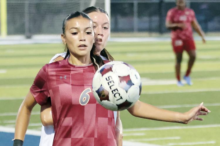 Aracely Martinez uses her body to screen off a Rose State player 