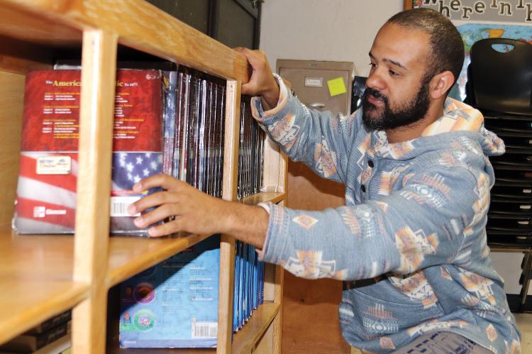 Tyler Hill straightens a line of American history books