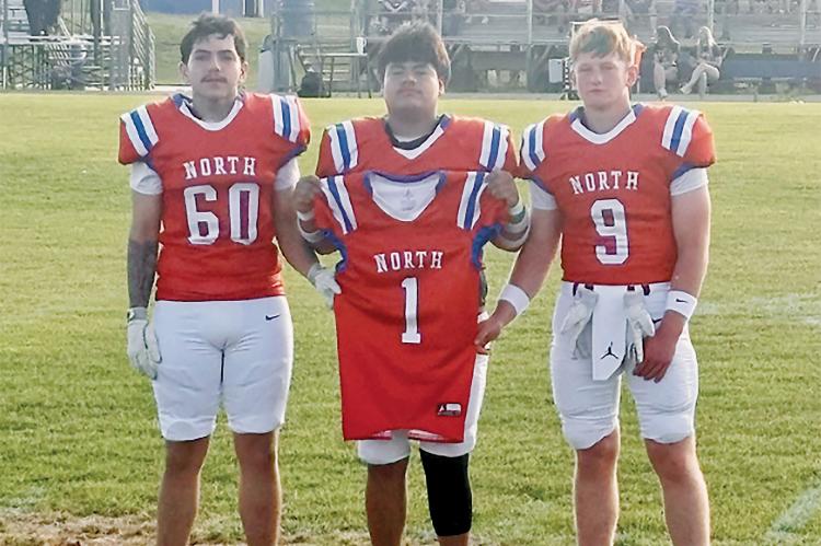 Omar Tristan (60), Jaron Youngbear and Rustyn Cook (9) carried Brad Palmer’s jersey during introductions