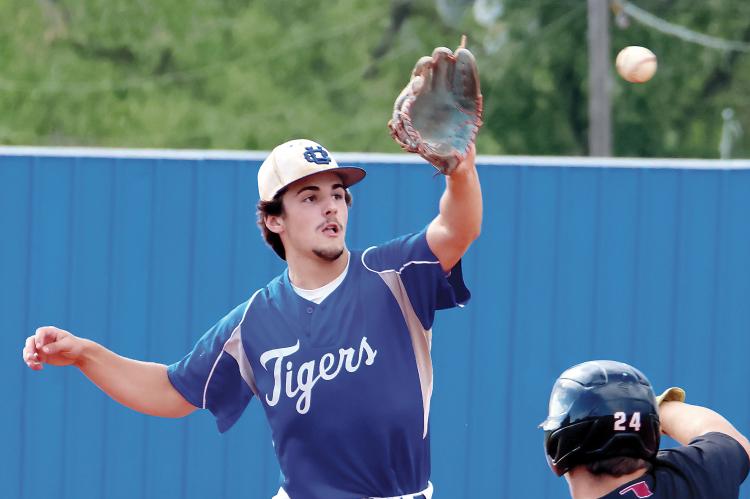 Blake Bailey leans over the bag to snag a relay throw as a OCA base runner slides into second