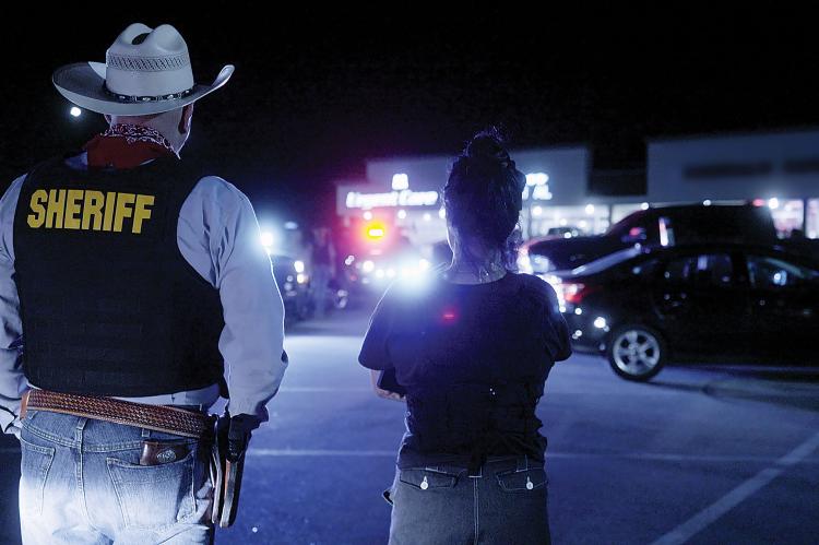 Chris West and Roo Powell watch as sheriff’s deputies make an arrest