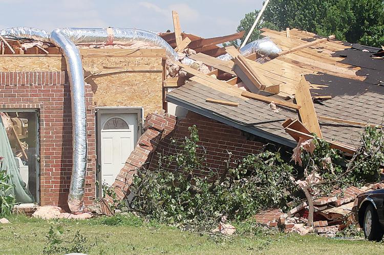 A storm repairman inspects a damaged home
