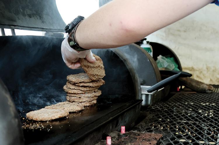 A worker with the ERPS summer food program stacks up burgers