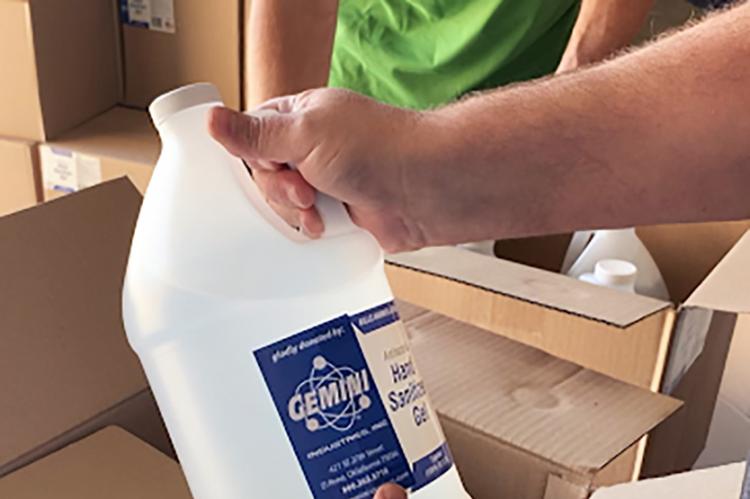 A worker checks a bottle of hand sanitizer