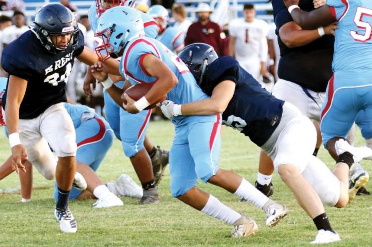 Mikey Devereaux (34) closes in to help Brody Robinson tackle a Lawton Eisenhower ball carrier.