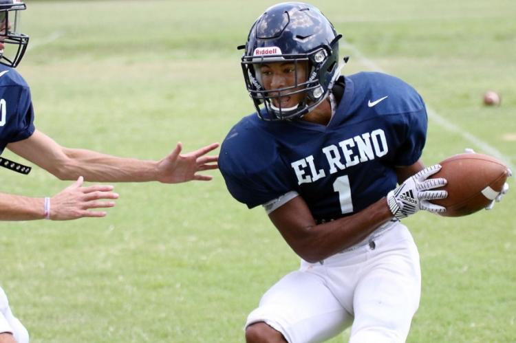 Gana Nicholson tries to dodge a tackler while clutching the football after catching a swing pass.