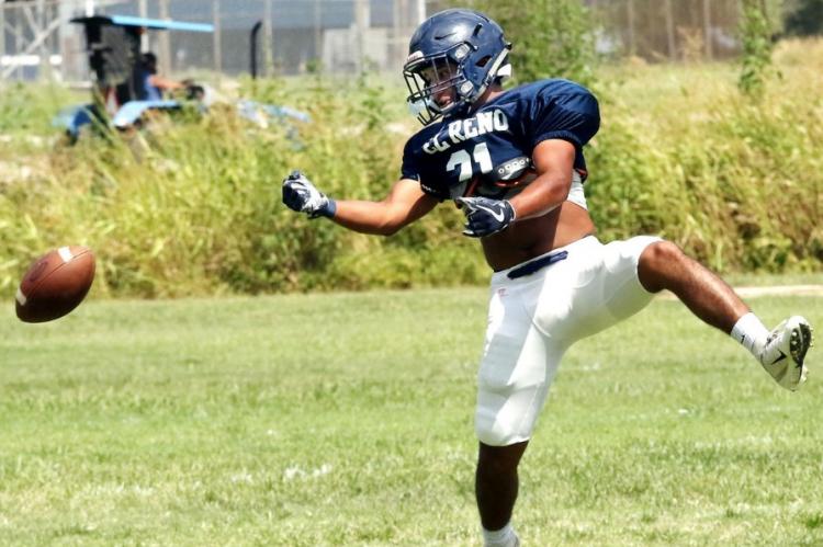 Tyler Vargas falls backward as the ball flies off his hands on a deep pass route.