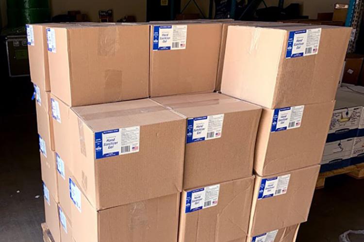 Boxes of hand sanitizer sit stacked on a pallet