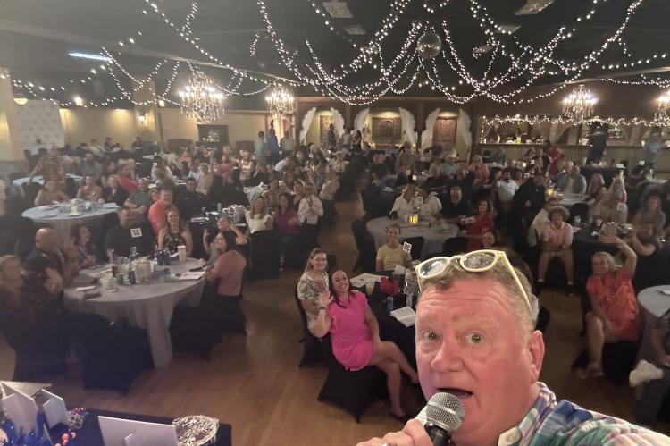 Matt White snaps a selfie while serving as auctioneer at the Festival of the Trees