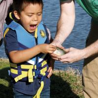 Ronin Sanchez reacts to touching the fish he caught