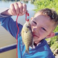 Ryder Jinkens of Yukon kisses a fish he caught