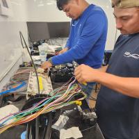 Andrew Jordan (left) and Austin Gravelis test and place fiber optic wires into a boar