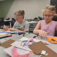 Riley and Rowyn McKee use markers