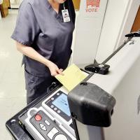 Kira Dutcher inserts her ballot into the counting machine