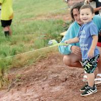 Ezekiel Chavez smiles while casting his line, with mom, Reagan Benton